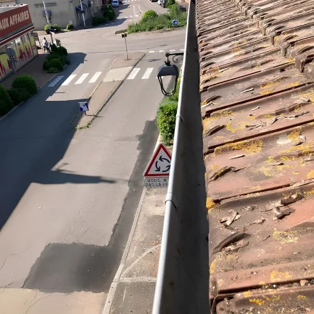 Nettoyage de gouttière sur une toiture en tuiles, intervention en hauteur