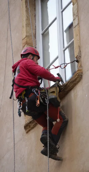 Cordiste en intervention sur la façade d'un bâtiment ancien